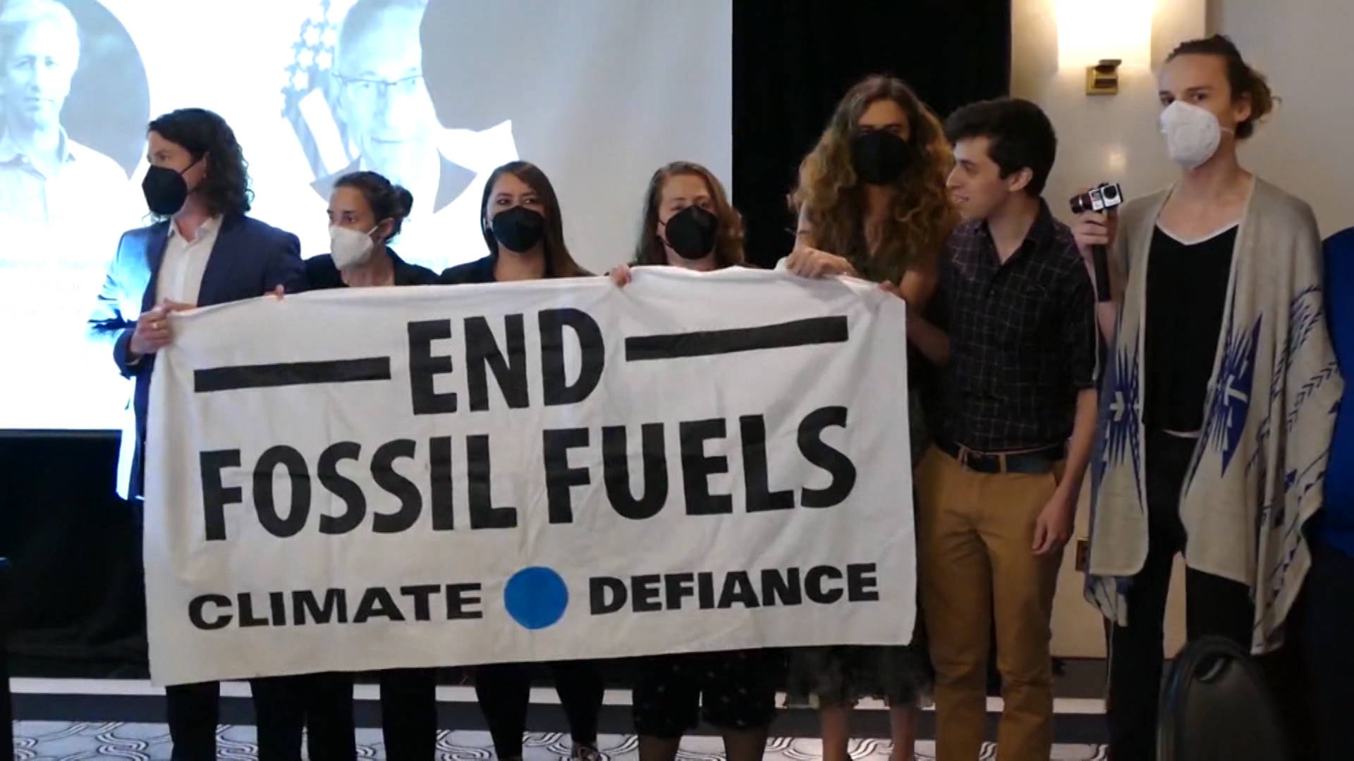 Climate Protesters Descend on Podesta Talk to Demand Biden Admin Halt Fossil Fuel Projects